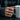Fleur-de-lis Cross Band Ring, rose gold, worn on model hand holding coffee mug