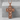 Memento Mori Cross Pendant, rose gold, front view on stone pedestal