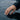 Close-up view of parametric ring worn on finger touching rippling water surface demonstrating sleek style
