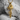 Wave dragon pendant in gold vermeil, front view on textured stone