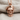 Military skull pendant, rose gold finish, front view on fabric