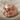Skull and Roses Ring, rose gold plated, front view on fabric background