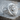 Scroll Jesus Christ Ring, polished silver, three-quarter view on wood