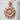 Bloom sunflower pendant, rose plated silver, front view on concrete block