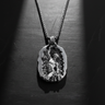 925 sterling silver self made man pendant showing muscular figure carving himself from stone on black background