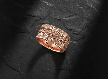 Angled view of wide band silver ring featuring deep relief carving of iron cross and acanthus leaves