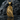 Close-up of the handcrafted gold vermeil crow pendant resting on dark rugged stones emphasizing the premium metalwork.