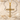Close-up of gold vermeil cross pendant with intricate stone settings displayed beautifully on white beach sand