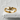 Clasping hands ring, gold vermeil finish, front view on stone surface