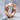 Rugged crater huggie hoop earring, rose gold, angled product view on stone