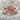 Secret Whisper Ring in rose gold, front view on stone surface