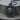 Bear Dog Tag Pendant in black rhodium, angled front view on wood