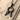 Bird Letter R Pendant, black rhodium, top view on sand and driftwood