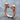 Twin Skull Ring, rose gold, angled view on rock surface