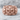 Fanged Demon Skull Ring, rose gold, front view on stone surface