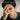 Male model wearing gold-tone doodle skull ring on index finger with hand covering face in editorial style shoot
