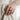 Handcrafted oxidized silver crown ring displayed on woman's index finger in clean aesthetic lifestyle setting