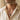 Man wearing oxidized silver acorn leaf pendant necklace on thin silver chain with unbuttoned cream linen shirt
