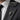 Climbing skeleton hand lapel pin worn on a charcoal suit blazer lapel for a dramatic gothic formal style
