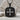 Acanthus Scroll Cross Pendant, black rhodium finish, front product view on rock
