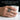 Man wearing handcrafted oxidized silver scorpion statement ring on index finger while holding white cup
