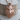 Tusked Wild Boar Pendant, rose gold plated silver, front view on wood base