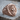 Scroll Jesus Christ Ring, rose gold, three-quarter view on wood