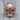 Ribbed Biomechanical Skull Ring, rose gold, front view on wood surface