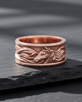 Rose gold plated silver horse ring featuring a detailed horse head relief on a textured slate background
