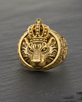 Front view of gold vermeil crowned lion ring handcrafted in 925 sterling silver on dark stone background