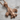Fleur De Lis Pendant, rose gold, angled front view on wood