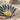 Macro close-up shot of two-tone Egyptian lotus pendant showing detailed gold vermeil inner petals on sand