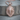 Layered Lion Pendant, rose gold, front view on wood base