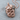 Coiled Serpent Apple Pendant, rose gold, product photo on wood base
