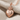 Hammered Sacred Heart Pendant, rose gold, product photo angled on fabric