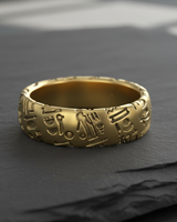 Gold vermeil ring featuring raised ancient Egyptian hieroglyphs and symbols on a dark slate surface