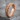 Devotion Band Ring, rose gold, angled view on stone base