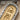 Macro detail of handcrafted gold vermeil plaque featuring sun disk and scarab hieroglyphs on cartouche pendant