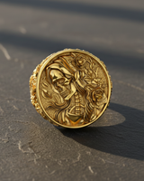 Gold vermeil grim reaper ring with skeleton and rose details on textured dark background