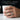 Close-up lifestyle view of man wearing oxidized silver cuneiform band ring while holding a ceramic cup