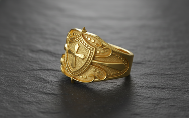 Angled perspective of medieval shield ring showing raised cross detail and intricate beaded borders