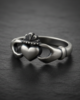 Side view of handcrafted sterling silver Claddagh ring showing detailed cuff and hand design with soft oxidized finish