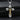 Gold plated orthodox cross pendant with detailed corpus and screw accents displayed on rock texture