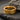 Warm rose gold finished Love Is Love ring with textured band background resting on a dark slate surface