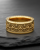 Gold-plated version of the Fleur-de-lis Cross Ring, showing the intricate royal pattern and polished band on a piece of stone.