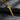 Radiant 14K gold vermeil winged sword pendant displayed on dark textured stone background