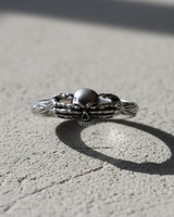 Front view of handcrafted silver death claddagh ring with intricate skull and hand design