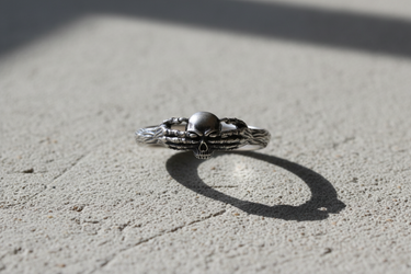 Front view of handcrafted silver death claddagh ring with intricate skull and hand design