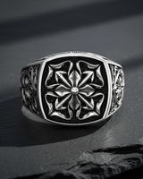 Front view of 925 sterling silver gothic cross ring with intricate floral cross motif on black stone background