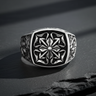 Front view of 925 sterling silver gothic cross ring with intricate floral cross motif on black stone background